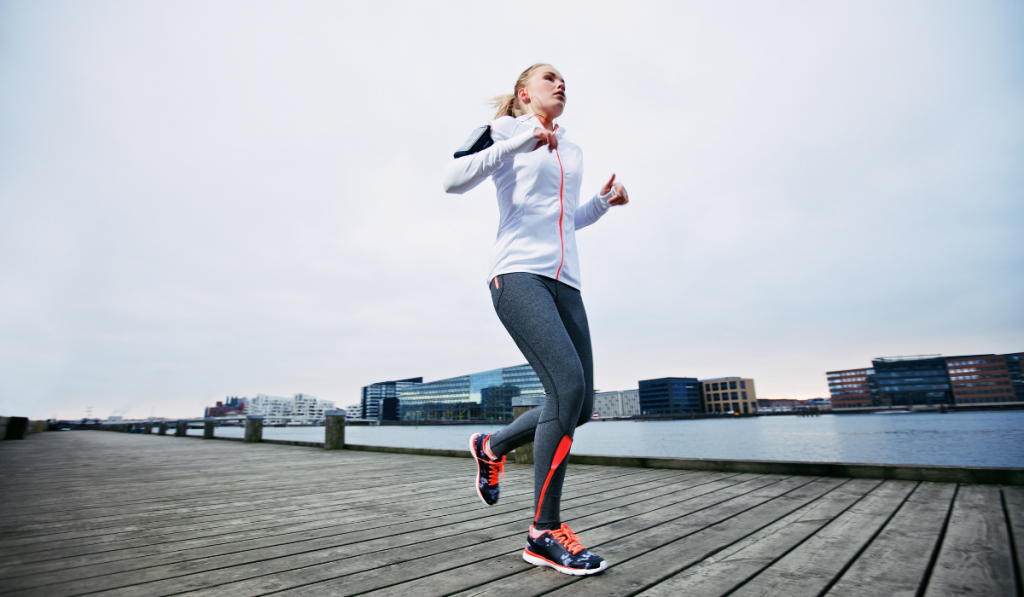 Young woman slowly running by the river