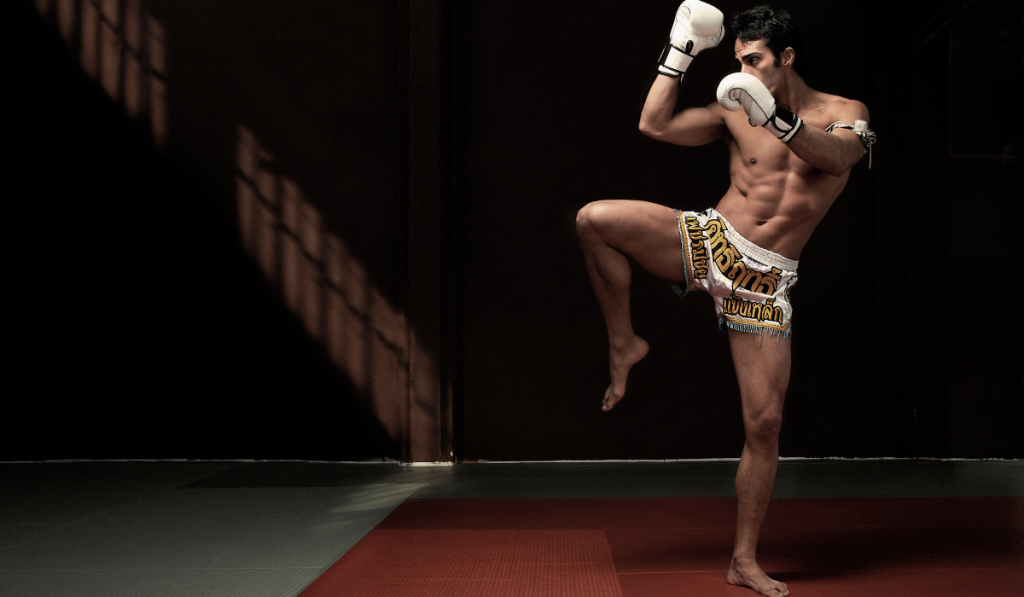 Boxer kicking on mat
