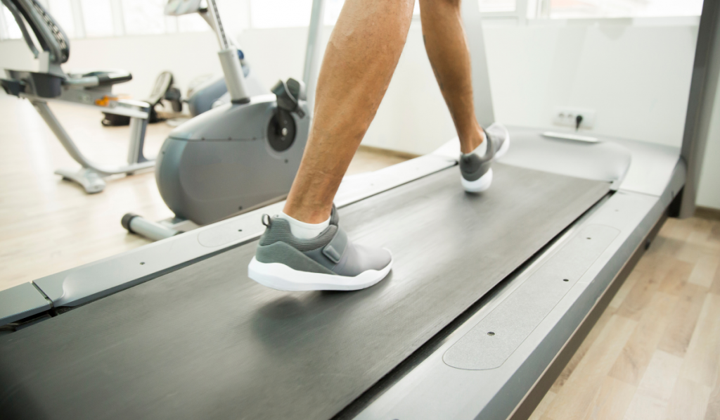 Close view of the male legs on a treadmill in the gym