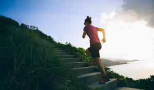 Determined-woman-running-up-on-seaside-mountain-stairs