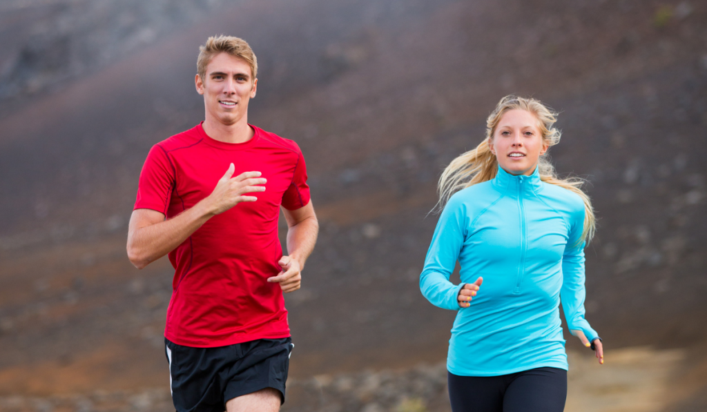 Fitness sport couple running jogging outside on trail

