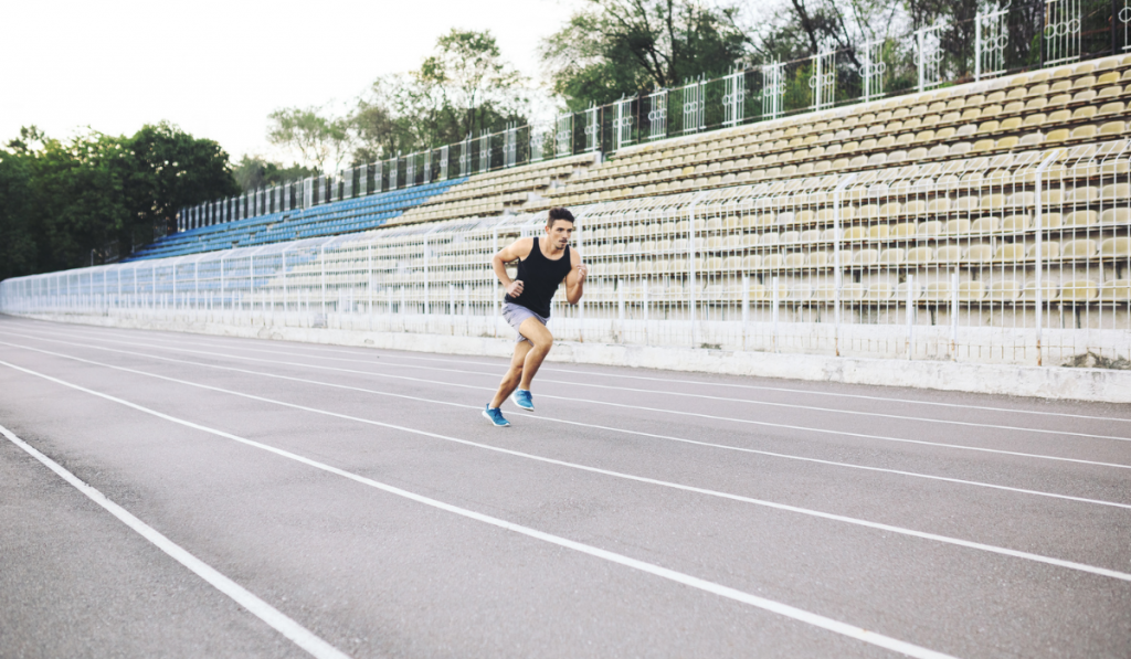 Athletic man running on a racing track