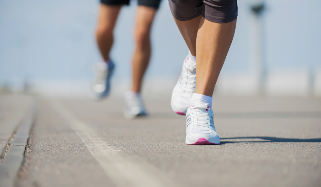 People running. Close-up image of woman and man running along the running track