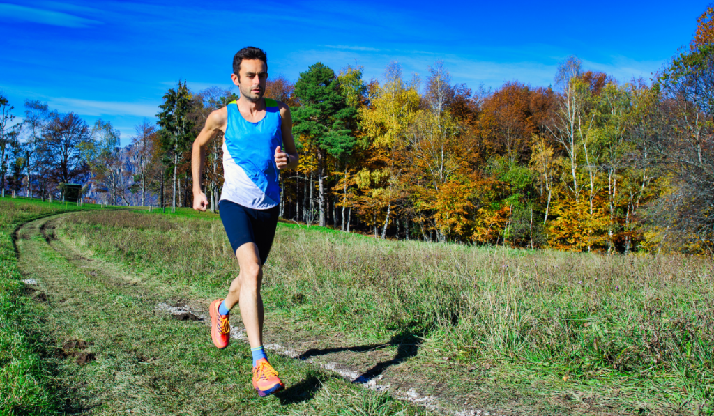 Running athlete during a workout among hillside meadows and woods