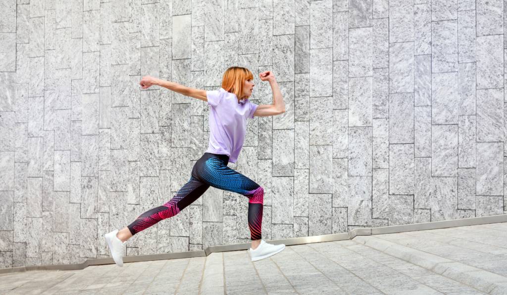 Sporty woman jogging through town running up an incline