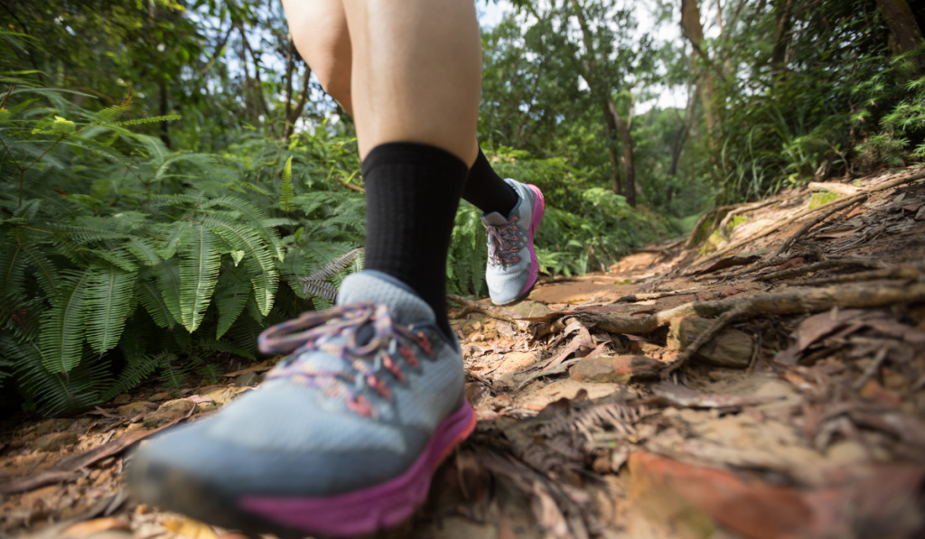 Woman ultra marathon runner running on tropical forest trail