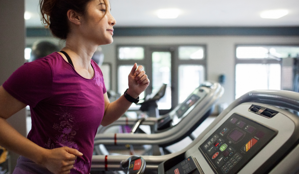 Woman Jogging On Treadmill At Gym