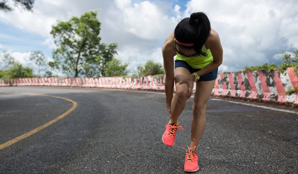 Woman runner suffering with pain on sports running knee