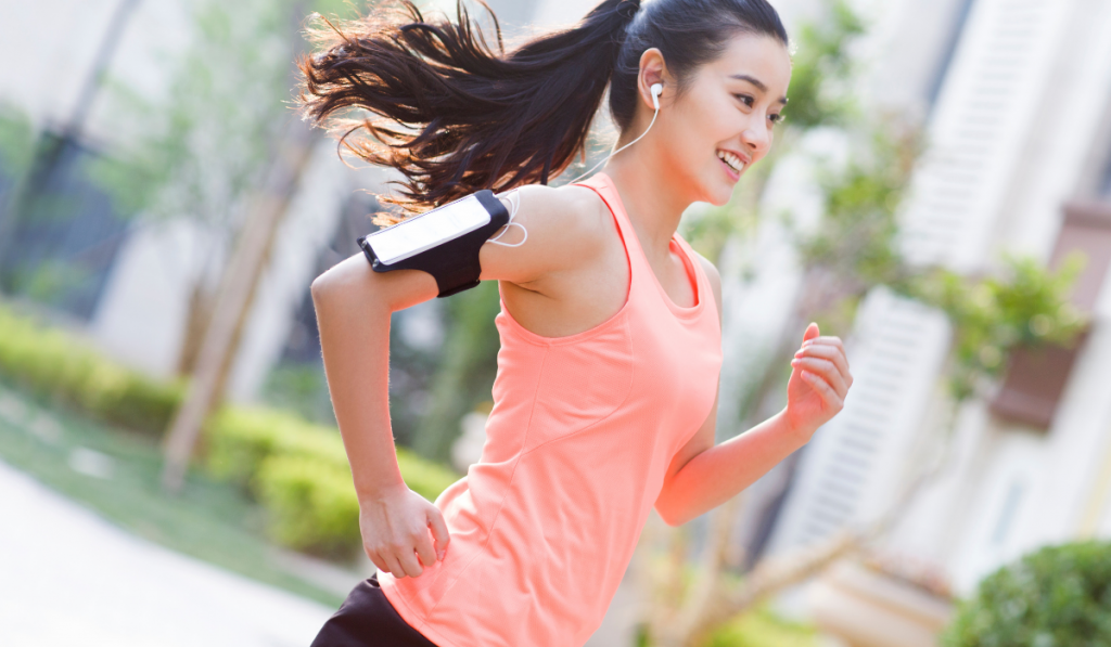 Young woman slowly running in the morning while listening to some music