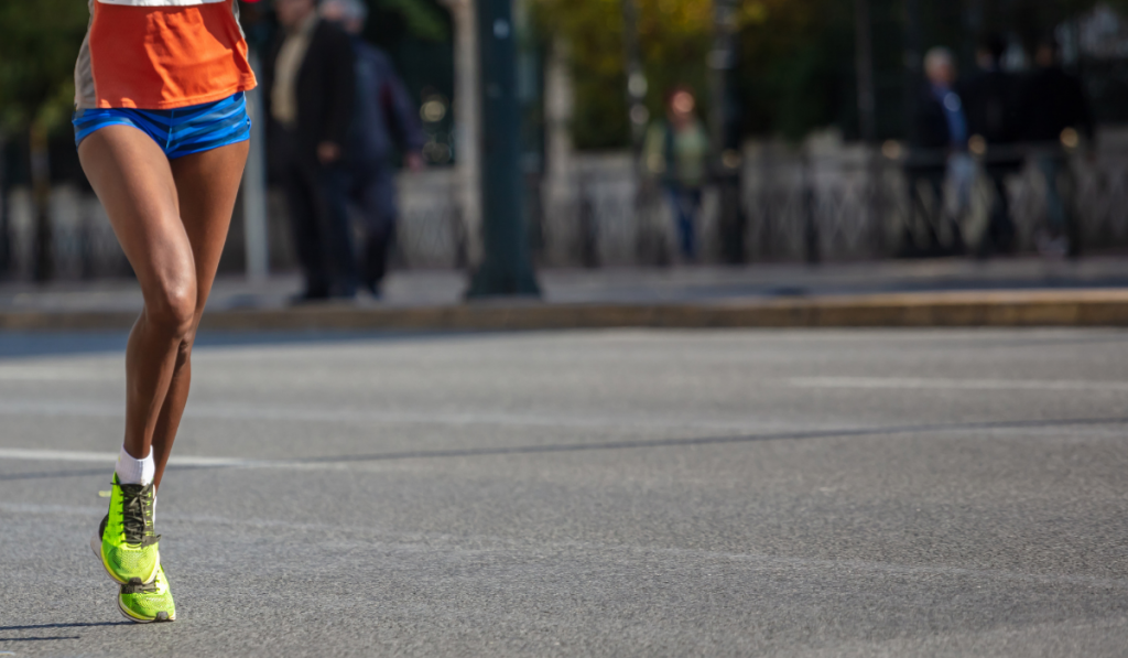 woman running in the city road using a forefoot strike running technique
