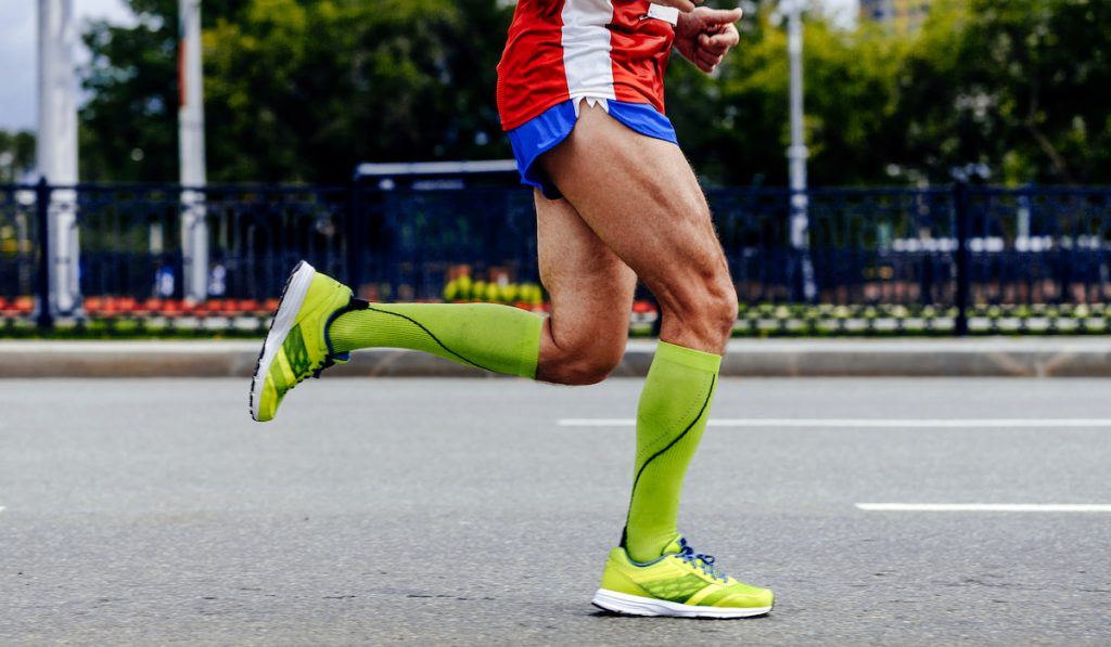sideview feet athlete man running blue short 
