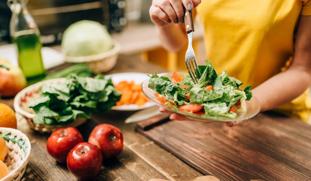 woman preparing salad on the kitchen