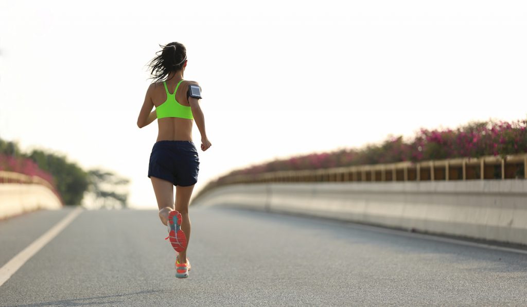 young fitness woman runner running on city road 