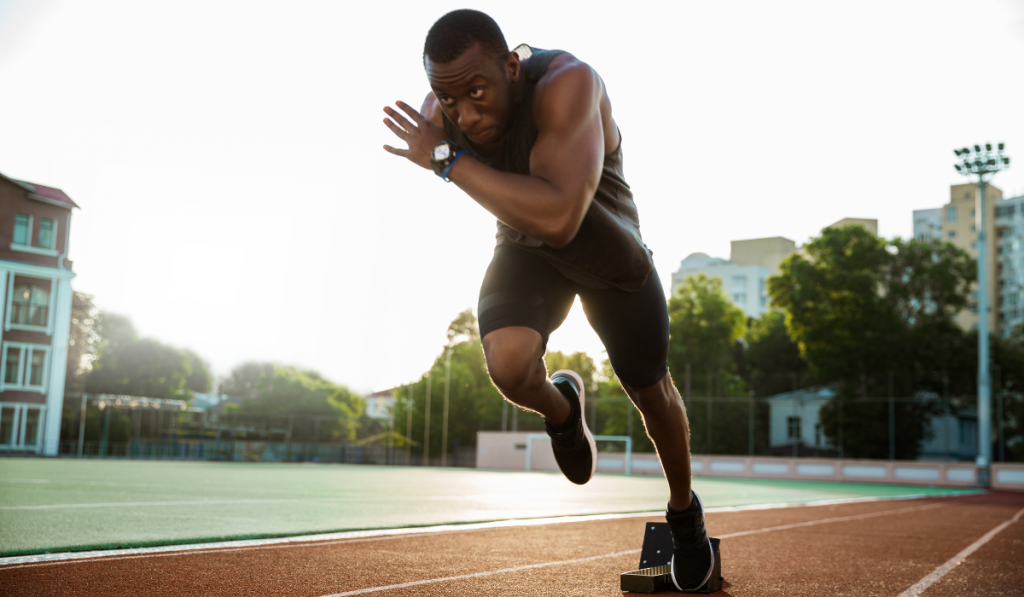 Young african runner running on racetrack